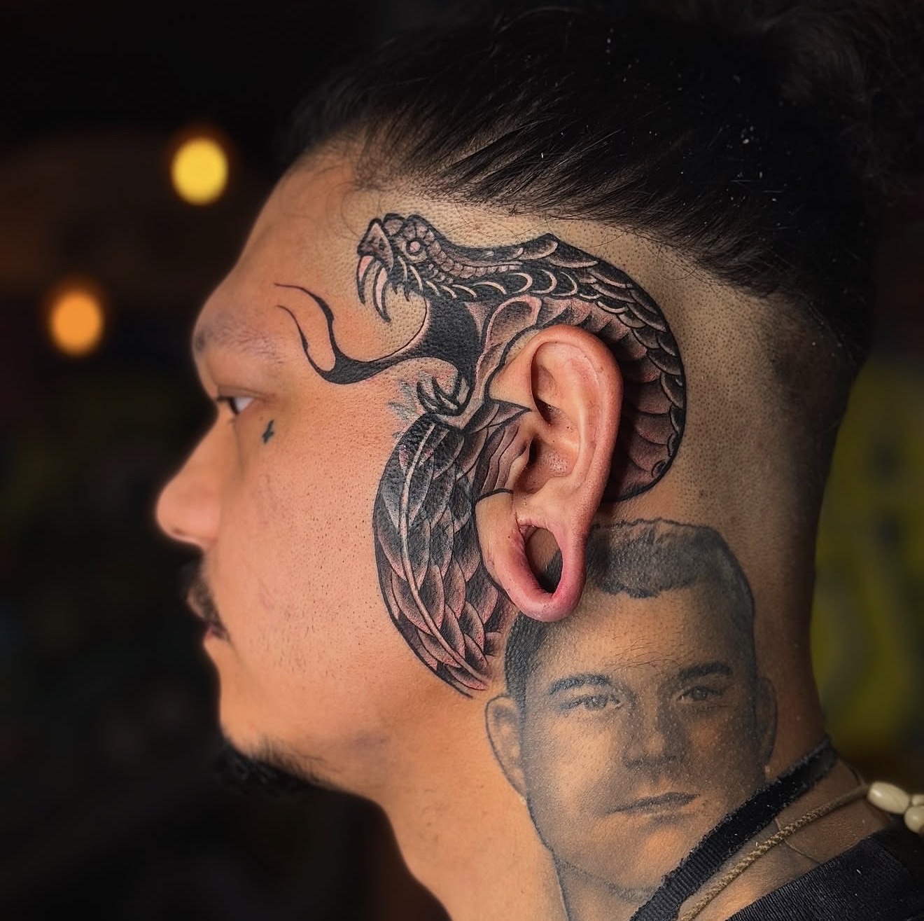 Neotraditional, black and gray snake tattoo on the side of a head. This is also a cover-up.